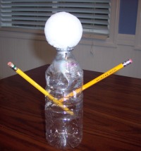 Recycled water bottle makes a mold for a ghost made of cheesecloth.